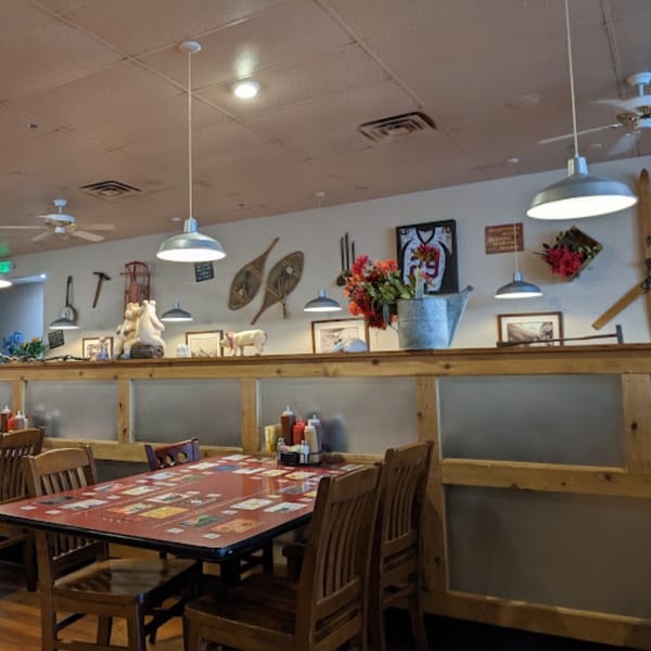 Rib City dining room with rustic decor, wooden tables, and hanging lights.