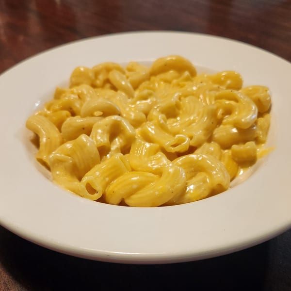 A white bowl filled with creamy, golden mac and cheese, a classic Rib City side.
